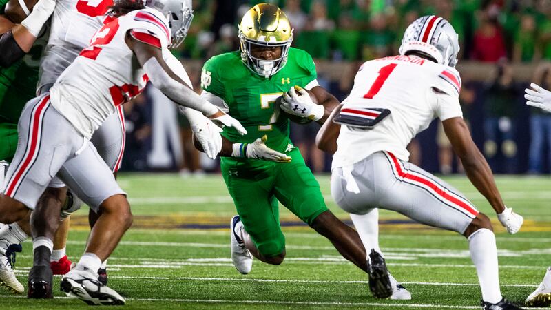 Notre Dame running back Audric Estimé (7) tries to get between Ohio State linebacker Steele...