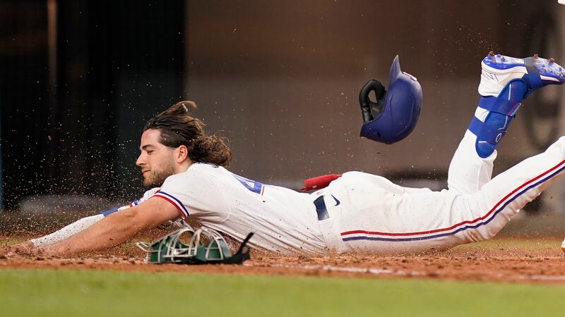 Texas Rangers Josh Smith slides safely into home plate for an inside-the-park home run during...