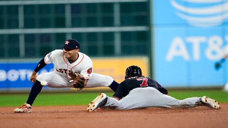 Washington Nationals' Trea Turner steals second with Houston Astros' Carlos Correa covering...