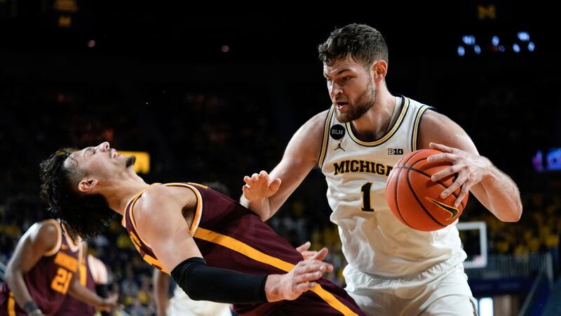 Michigan center Hunter Dickinson (1) drives on Minnesota forward Dawson Garcia (3) in the...