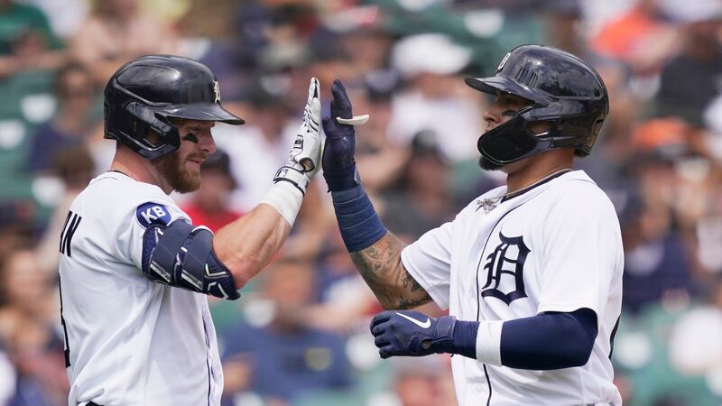 Detroit Tigers' Javier Baez, right, is greeted at home plate by teammate Robbie Grossman after...