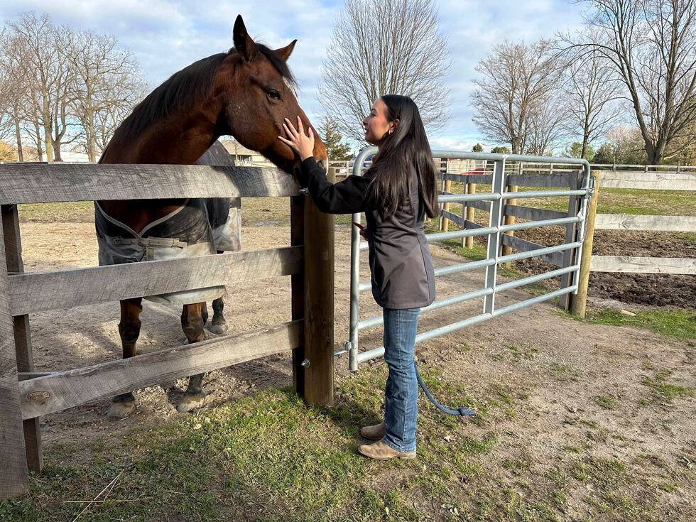 Kylie Ossege greets her horse, Blaze, at a boarding facility Saturday, Nov. 11, 2023, in...